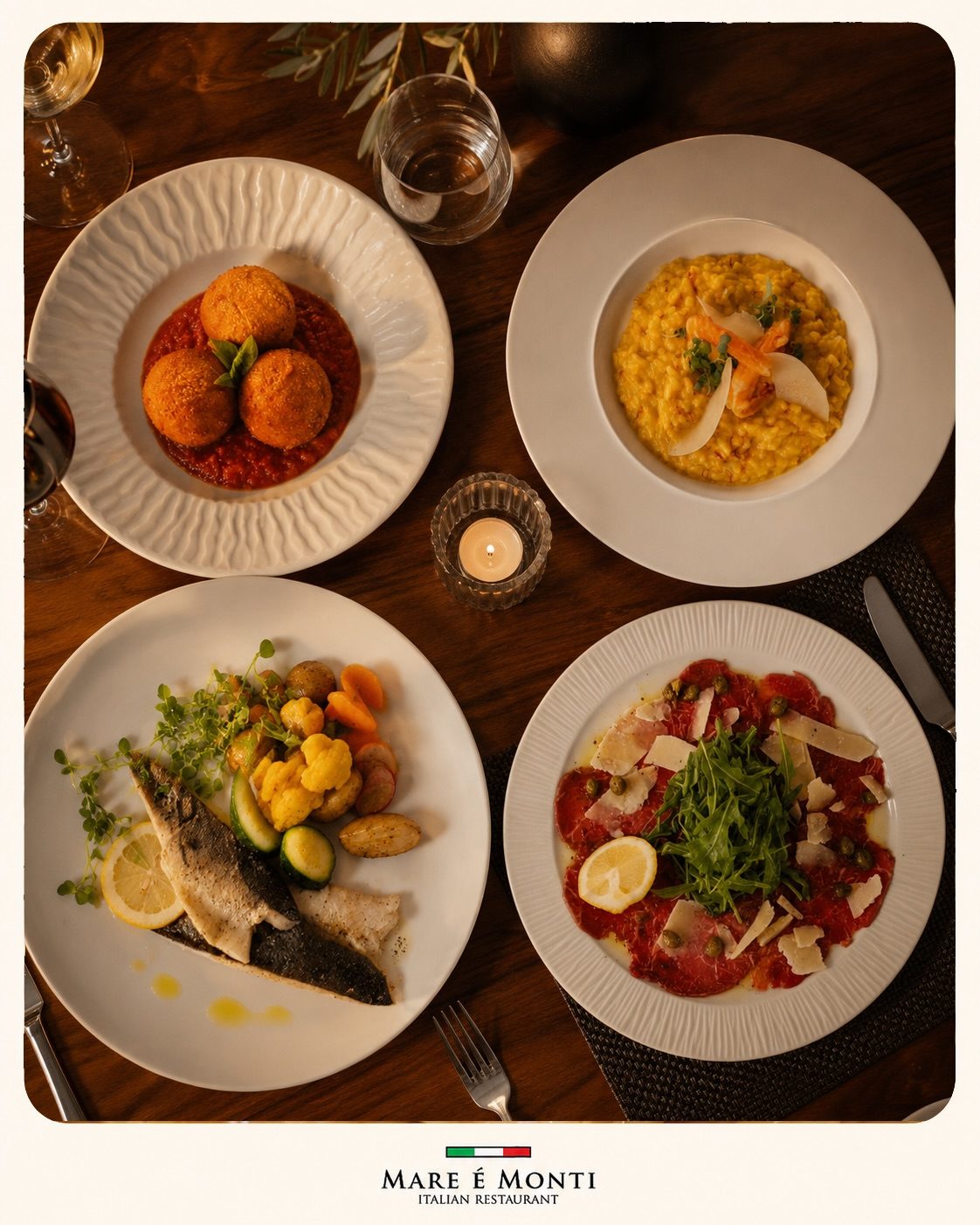 Four dishes laid out on a dark wooden table by candlelight